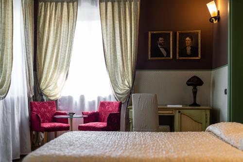 a bedroom with a bed and two chairs and a desk at Residenza Villa Vecelli Cavriani in Mozzecane