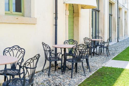 a row of tables and chairs on a sidewalk at Residenza Villa Vecelli Cavriani in Mozzecane