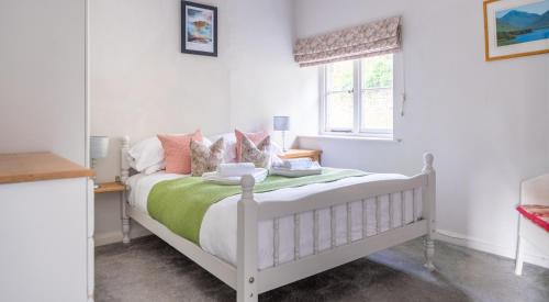 1 dormitorio con cama blanca y ventana en Wastwater, en Sawrey