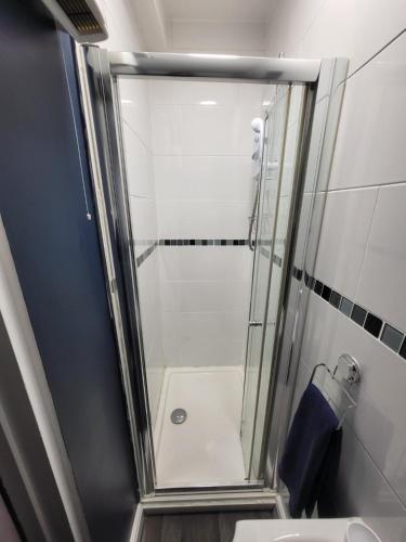 um chuveiro com uma porta de vidro na casa de banho em City Centre Studios 3 em Leicester