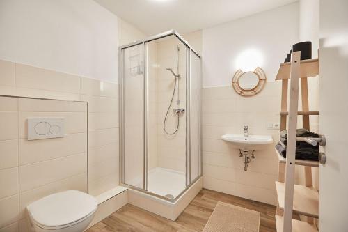 a bathroom with a shower and a toilet and a sink at Ferienwohnung zum Steingarten in Krün
