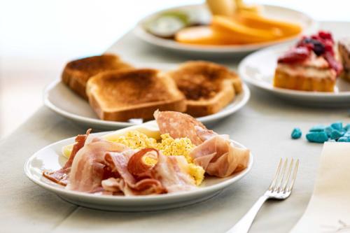 a table topped with plates of breakfast foods and toast at Centro Vacanze Domus M.G. in San Benedetto del Tronto