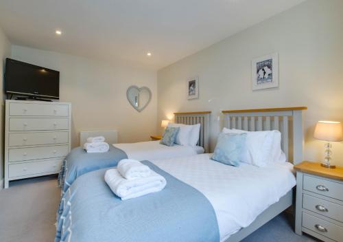 a bedroom with two beds with towels on them at The Haven in Southwold