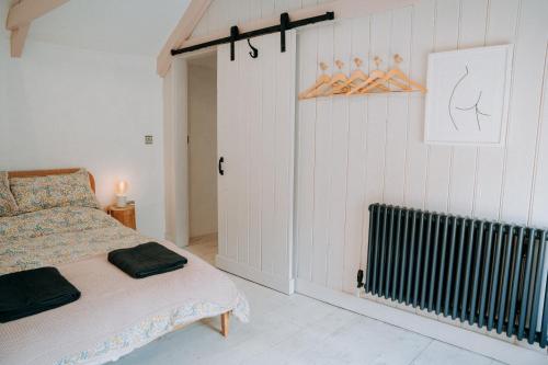 a bedroom with a bed and a radiator at Cute and cosy 2 bed cottage in beautiful Solva in Solva