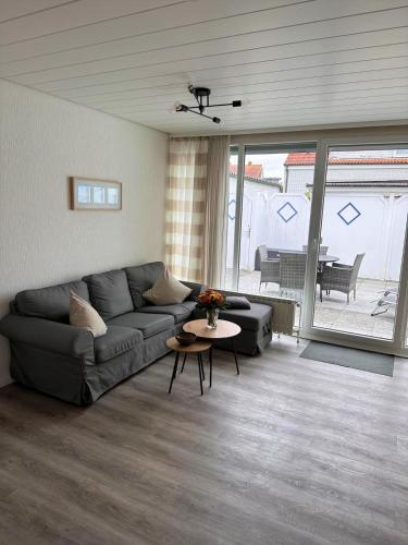 una sala de estar con un sofá y una mesa en Bungalow Süüdstraat, en Norderney