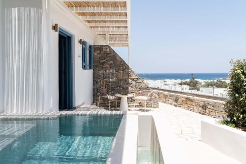 a villa with a swimming pool and a patio at Aura Suites Paros in Naousa