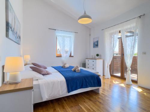 a bedroom with a bed with a blue blanket at Villa Berenice in Butkovići