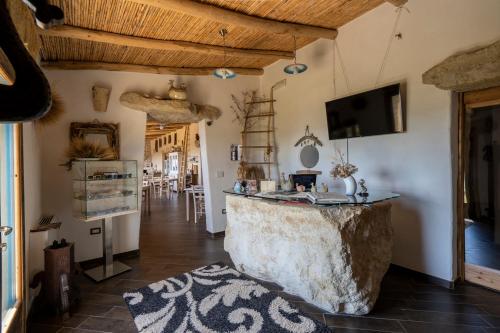 Is Perdas Rural Retreat & Spa في Gergei: غرفة معيشة مع صخرة كبيرة في وسط الغرفة