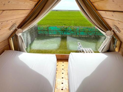 een kamer met een raam met uitzicht op een veld bij Lushna 3 Petite at Lee Wick Farm Cottages & Glamping in Clacton-on-Sea