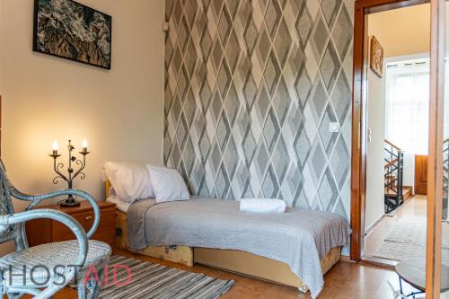 a small bedroom with a bed and a chair at VILLA57 - Balatonalmádi - hostAID in Balatonalmádi