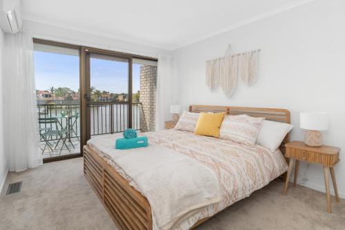 a bedroom with a bed and a balcony at Absolute Waterfront Marina Views in Patterson Lakes