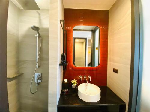 two pictures of a bathroom with a sink and a shower at Edge Central Pattaya Vip Condo in Pattaya Central