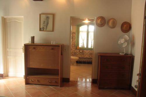 a bathroom with a dresser and a toilet and a mirror at Chambres d'hôtes MoulinDT in Virazeil