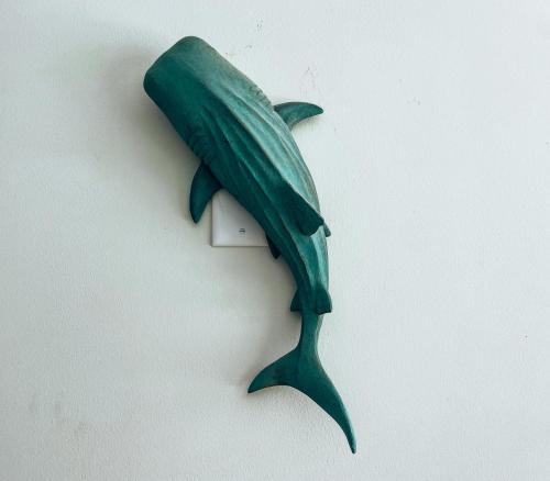 a green fish hanging on a wall at El Sitio Village in Playa Venao