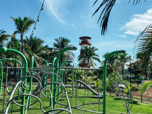 a park with a red lighthouse in the background at El Sitio Village in Playa Venao