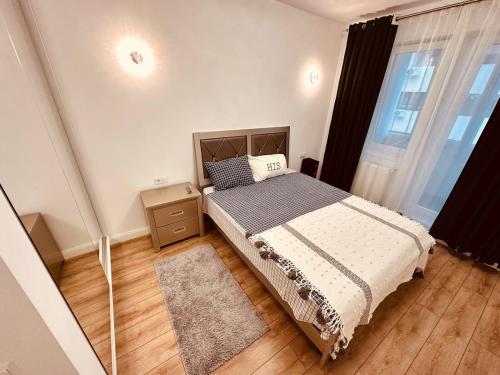 a bedroom with a bed and a large window at Avangarde Apartment in Bucharest