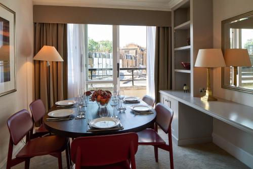 a dining room with a table and chairs and a window at Cheval Knightsbridge in London
