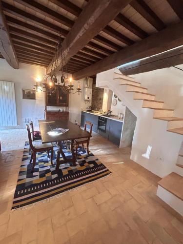 a dining room with a table and chairs and a staircase at Casa Fossatello in Nocera Umbra