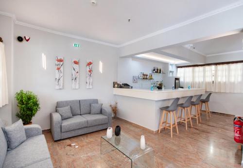 a living room with a couch and a bar at Hotel Nostos in Nydri