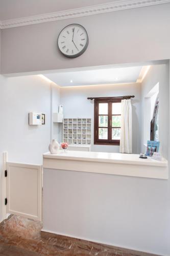 a kitchen with a clock on the wall and a window at Hotel Nostos in Nydri