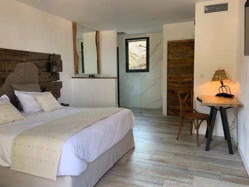 a bedroom with a bed and a table and a desk at VILLA MACAGNA in Corbara