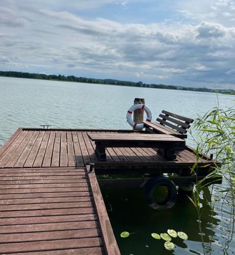 a dock with a bench sitting on top of a lake at Piękna Góra in Giżycko