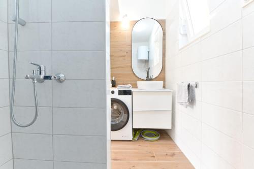 a bathroom with a washing machine and a mirror at Holiday Home Greystone in Omiš