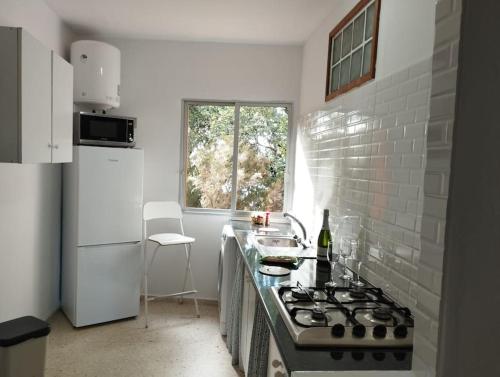 a kitchen with a stove and a sink and a window at Monte Verde in Chinamada