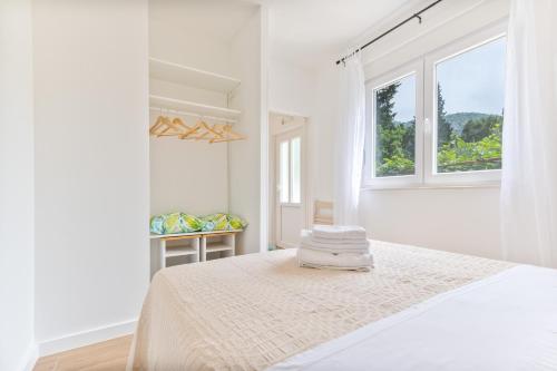 biała sypialnia z łóżkiem i oknem w obiekcie Holiday Home Greystone w Omišu