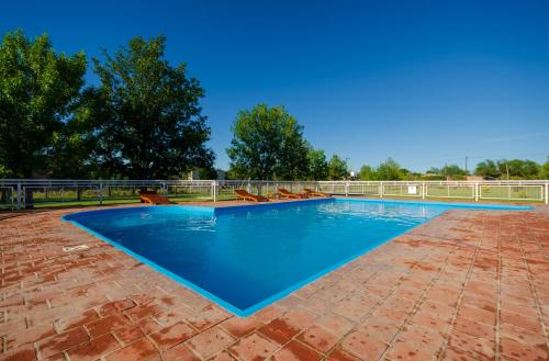 una piscina con agua azul en un patio de ladrillo en Complejo Linda vista en Nono