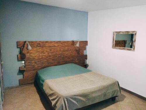 um quarto com uma cama e uma cabeceira em madeira em Aur Blan - Chambres Le Somail em Le Somail