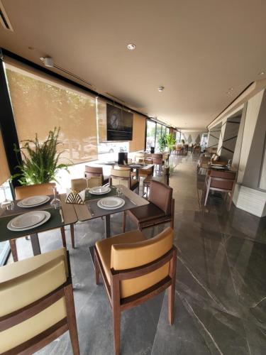 ein Restaurant mit Tischen und Stühlen und einem großen Fenster in der Unterkunft Hotel Appartement Tanger in Tangier
