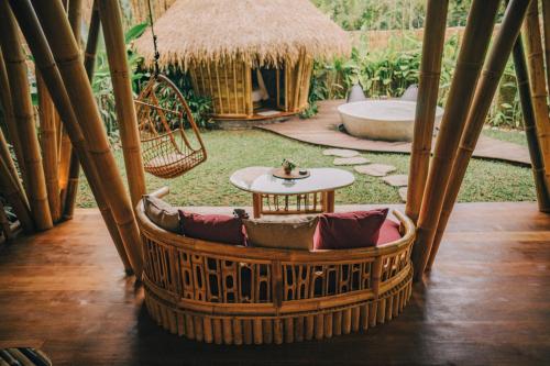 a room with a hammock and a table at Balikayanas - Ellena House in Karangasem