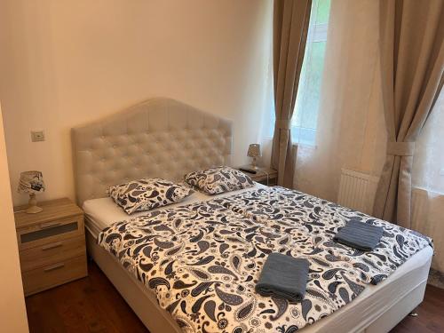- une chambre avec un grand lit et une couette blanche et noire dans l'établissement Jurincom apartments na Vyhlidce, à Karlovy Vary