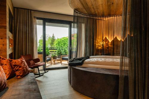 a bedroom with a large bed with a large window at Araldo Eco-Lodge in Bosco Chiesanuova
