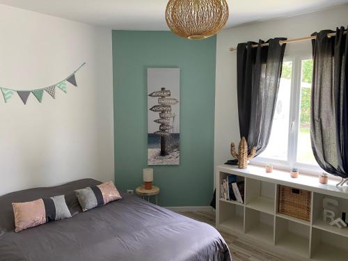 une chambre avec un lit et une fenêtre dans l'établissement Villa avec piscine chauffée proche plage Océane, à Le Temple