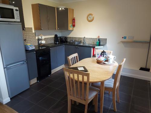 a kitchen with a table and chairs and a kitchen with a refrigerator at The Chalets in Eskdale