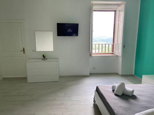La Dolce Vita في كاميروتا: غرفة بيضاء مع سرير ونافذة