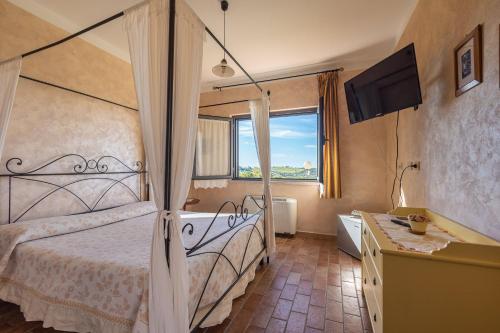 Schlafzimmer mit einem Bett, einem TV und einer Badewanne in der Unterkunft Agriturismo La Meria in Semproniano