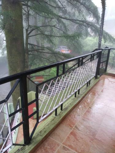 a black fence with a view of a tree at Bhawani Kutir Villa Nainital in Nainital