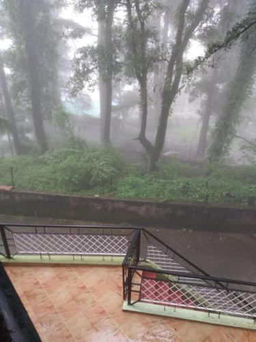 a view of a garden in the rain from a window at Bhawani Kutir Villa Nainital in Nainital