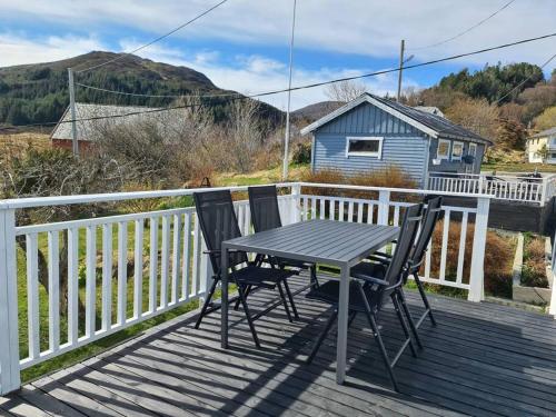 a table and two chairs sitting on a deck at Koselig hus med hage i Herøy på Sunnmøre. in Røyra