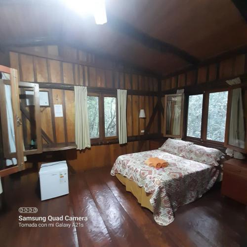 a bedroom with a bed in a room with windows at Yasí Yateré Reserva Agroecológica in El Soberbio