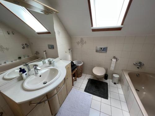 a bathroom with a sink and a tub and a toilet at FEWO-Ammermann in Plön