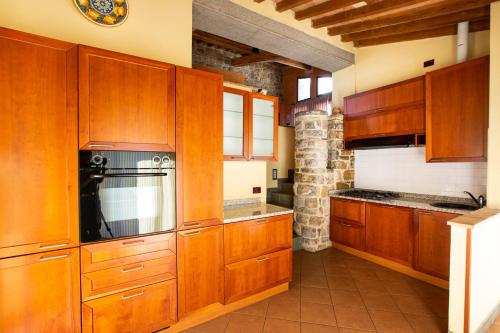 a kitchen with wooden cabinets and a stove at Fattoria Le Fonti in Poggibonsi