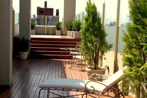 balcone con sedie, tavolo e alberi di Hotel Intersur Recoleta a Buenos Aires