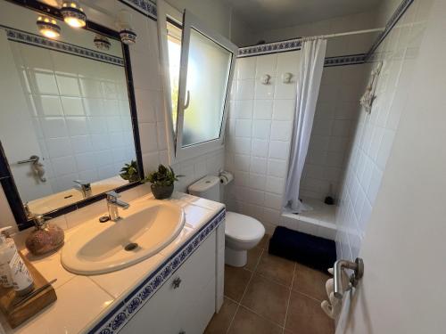 uma casa de banho com um lavatório, um WC e um espelho. em Casa Triana em Torroella de Montgrí