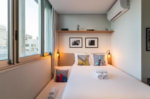ein kleines Schlafzimmer mit einem Bett und einem Fenster in der Unterkunft Studio aconchegante e decorado na Bela Vista in São Paulo
