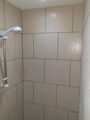 bagno con doccia e piastrelle bianche di Southbay Room 2 a Bridlington