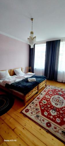 a bedroom with two beds and a rug at guest house lela rezo in Stepantsminda